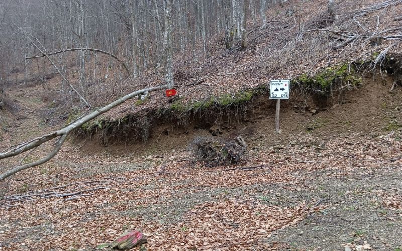 A red and white hiking signs iA dirt road on a hike in Paiko mountain northern Greece.