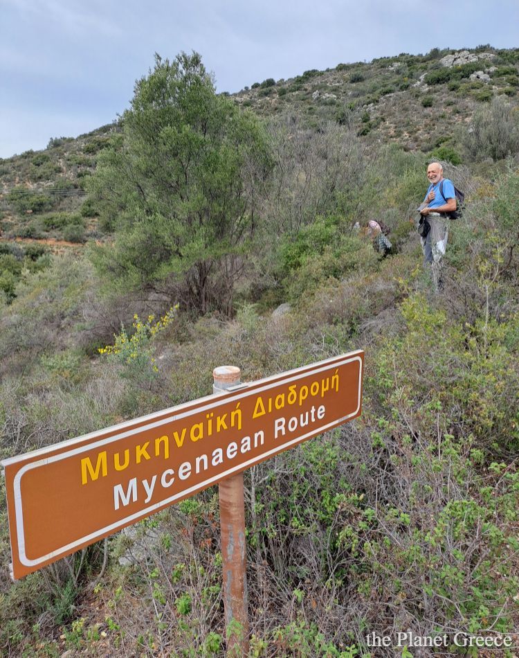 A hiking sign saying Mycenaean route with ahiker in the Peloponnese. 