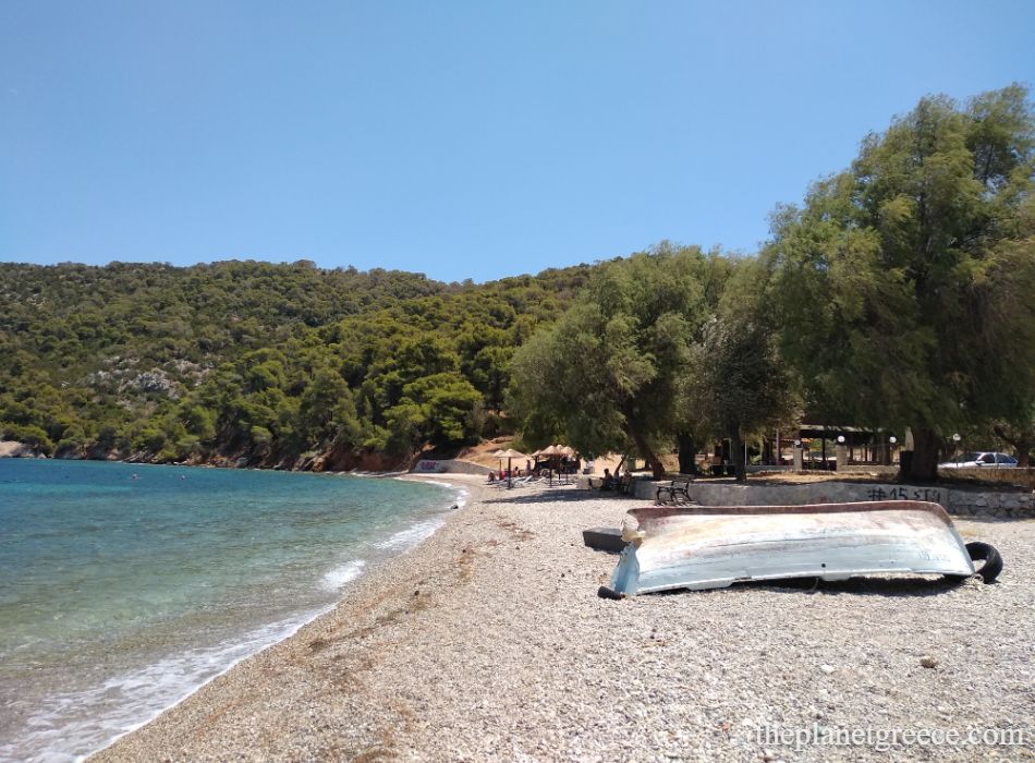 Quiet pebbled beach with turquoise water and pine trees near Loutra Oraias Elenis, close to Corinth.