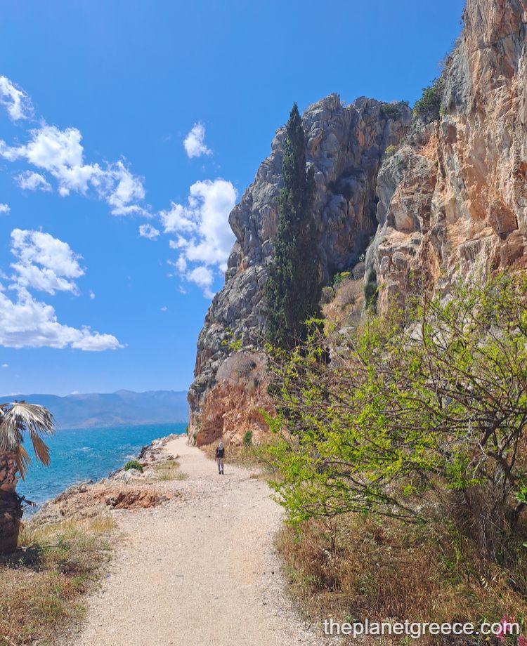 Hiker on the Nafplio coastal hike near Arvanitia headland. Hiking in Nafplio.