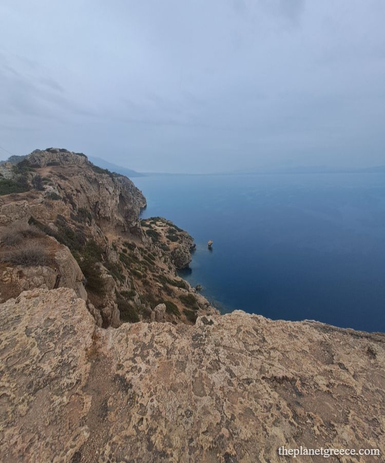 Panoramic view of cliffs and deep blue sea near Melagkavi Lighthouse in Loutraki, Greece.